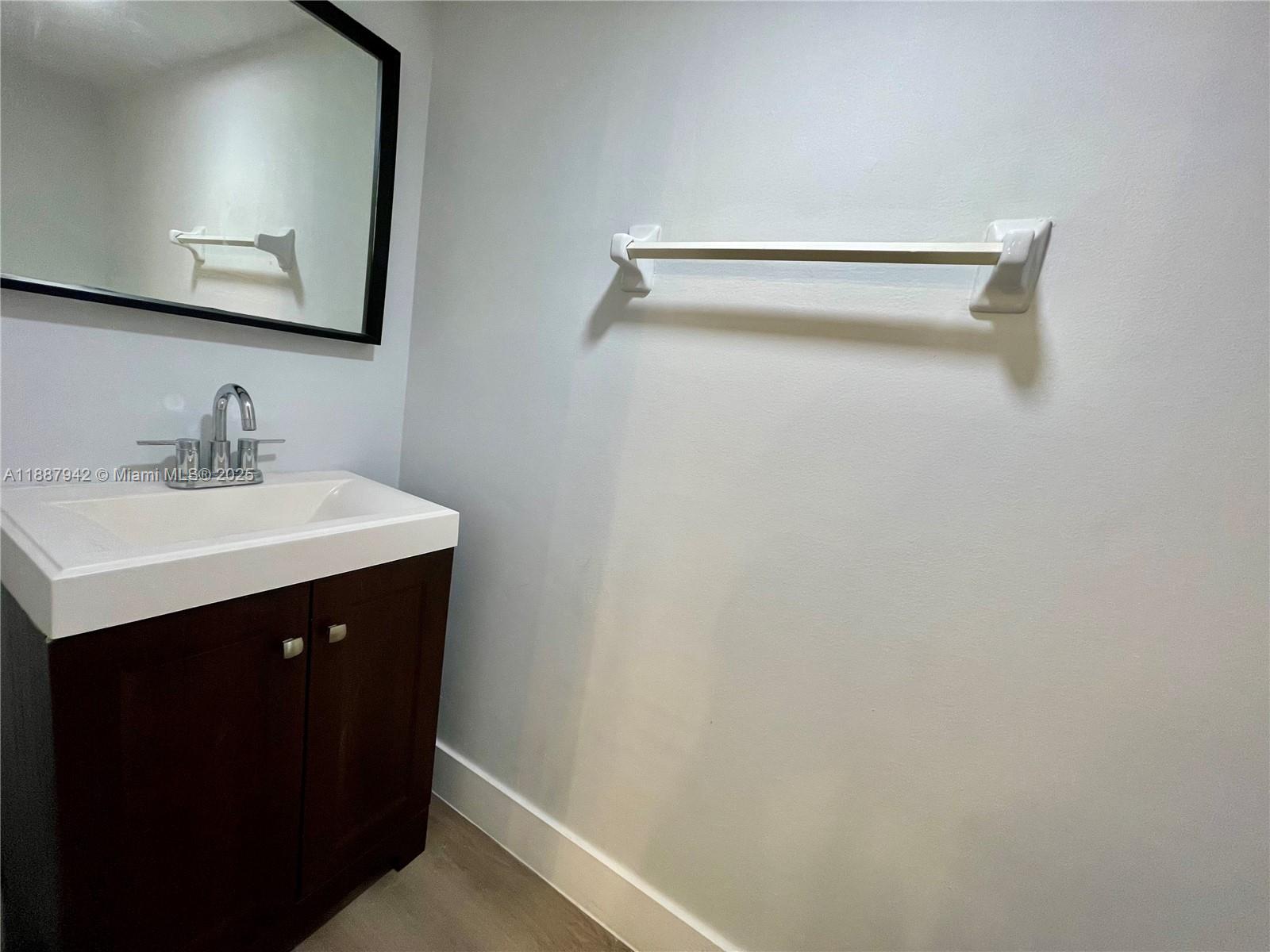 3680 Inverrary Drive, Unit 2B Lauderhill, FL 33319 - Photo 5 of 12 a bathroom with a sink vanity and mirror