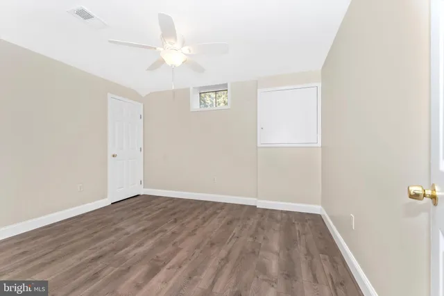 an empty room with a white cabinet and a ceiling fan
