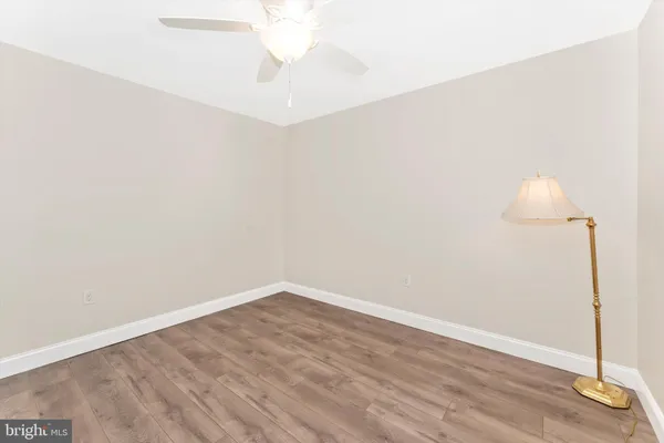 an empty room with wooden floor and mirror