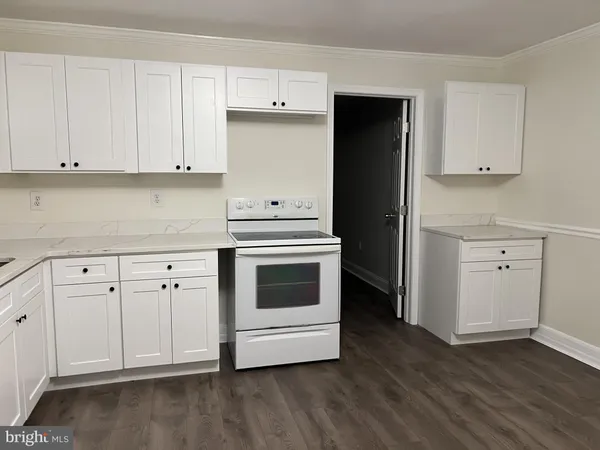 a kitchen with granite countertop white cabinets and white appliances