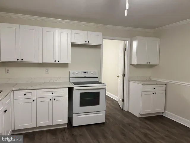 a kitchen with white cabinets and white appliances