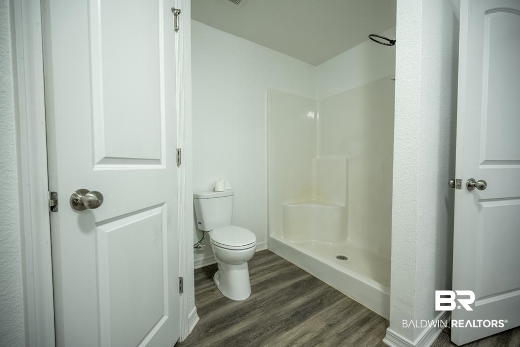 15874 Carver Road, Unit C Foley, AL 36535 - Photo 14 of 18 Bathroom with a shower, toilet, and hardwood / wood-style floors