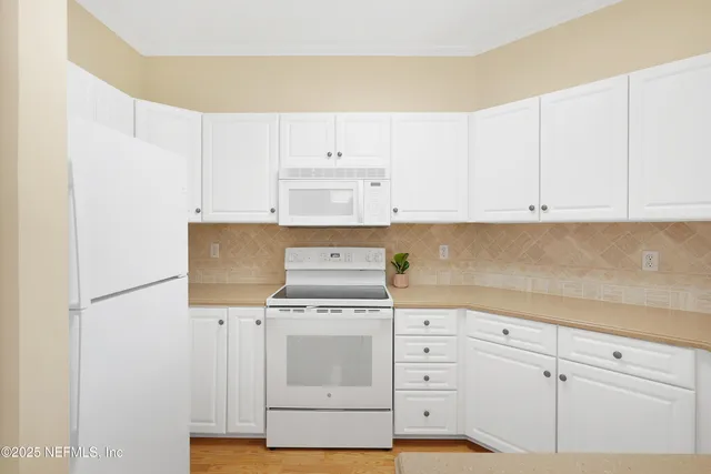 a kitchen with white cabinets appliances and sink