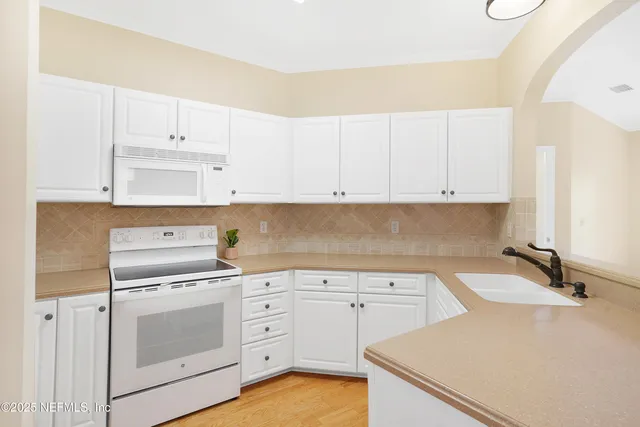 an empty room with windows and ceiling fan