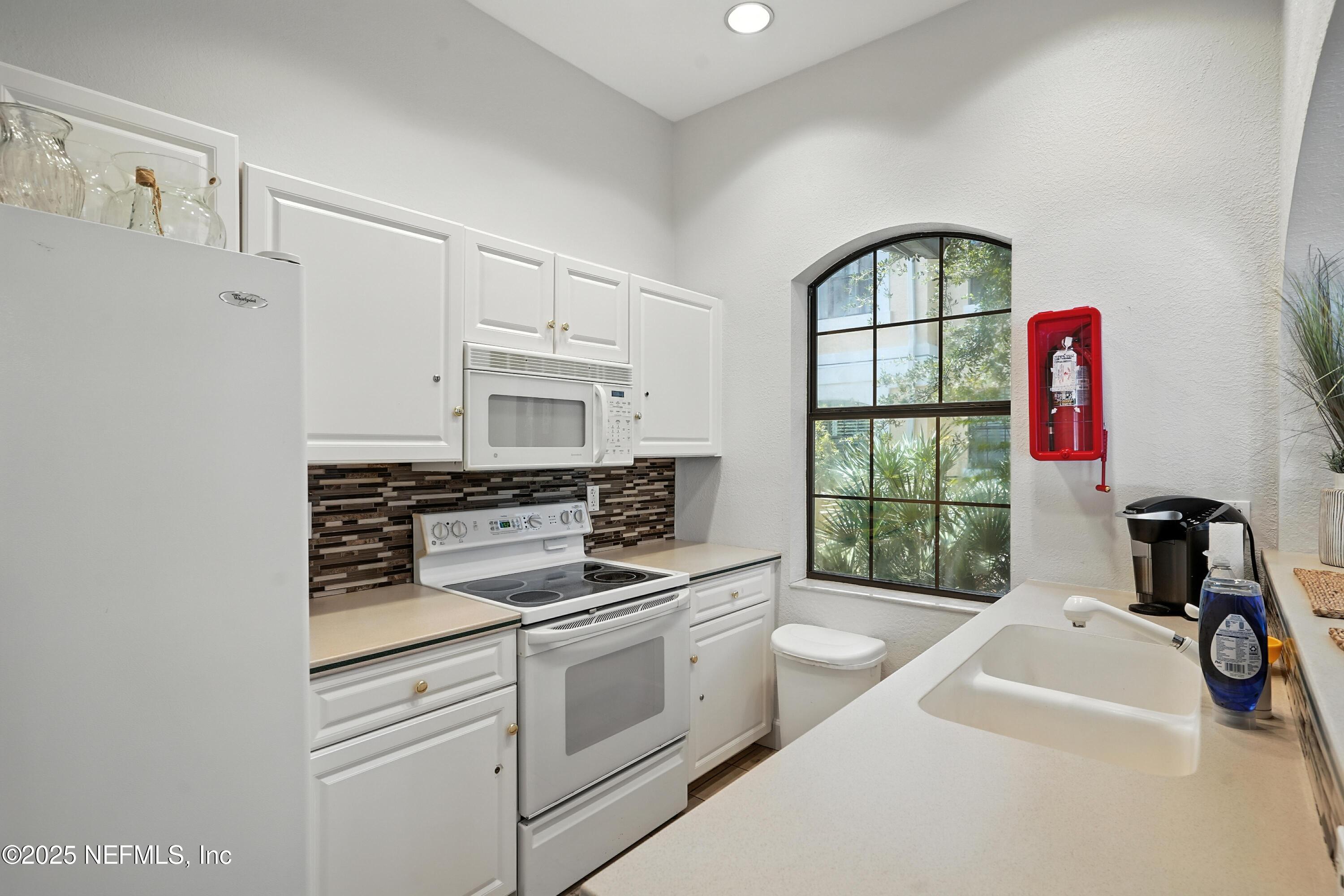 2827 Vista Cove Road St. Augustine, FL 32084 - Photo 53 of 59 a kitchen with a stove a sink and a window