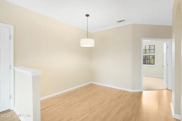 a view of a hallway with wooden floor and a living room