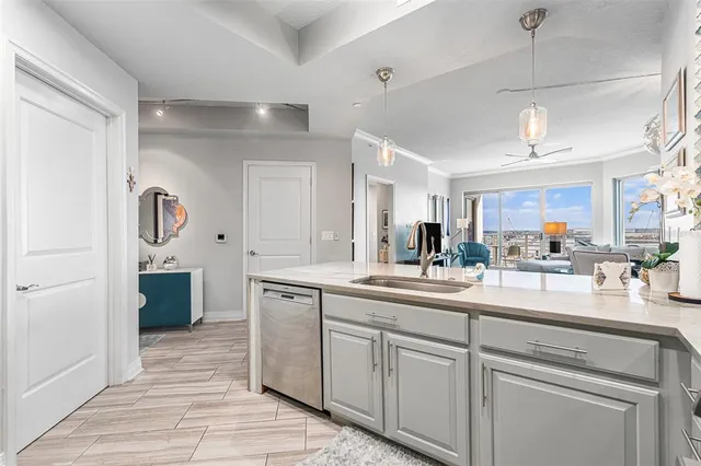 a kitchen with white cabinets and sink