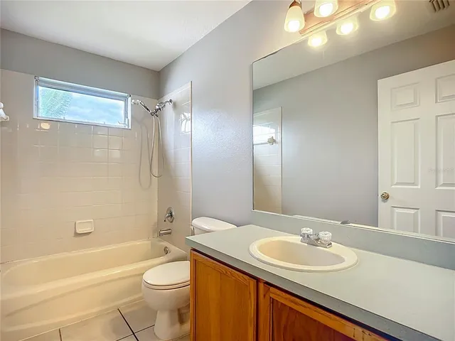 a bathroom with a granite countertop sink toilet mirror and bathtub