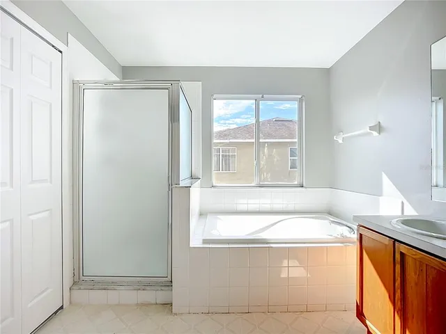 a spacious bathroom with a tub sink and mirror