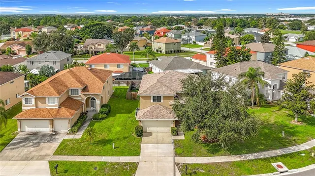 an aerial view of residential houses with outdoor space and trees