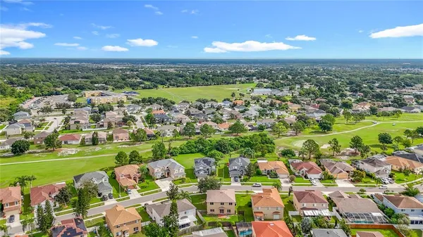 an aerial view of residential houses with outdoor space and trees