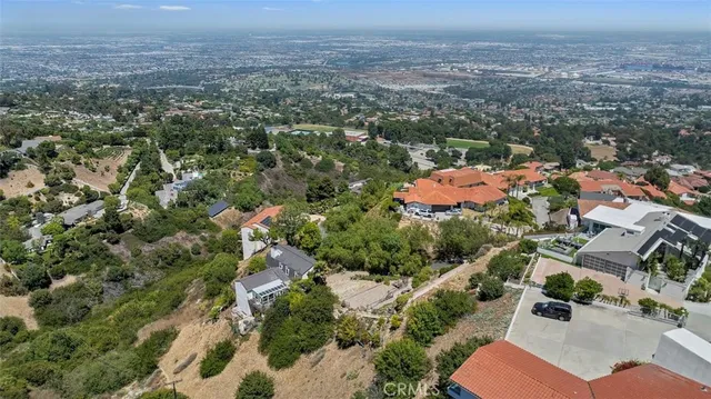 an aerial view of residential houses with outdoor space and trees