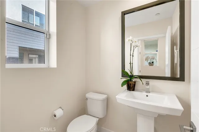 a bathroom with a toilet a sink and mirror