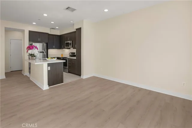 a kitchen with stainless steel appliances kitchen island granite countertop a stove and a refrigerator