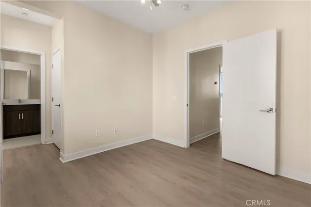 an empty room with wooden floor and closet