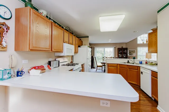 a kitchen with stainless steel appliances granite countertop a sink dishwasher and white cabinets with wooden floor
