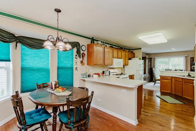 a view of a dining room and livingroom with furniture wooden floor a chandelier