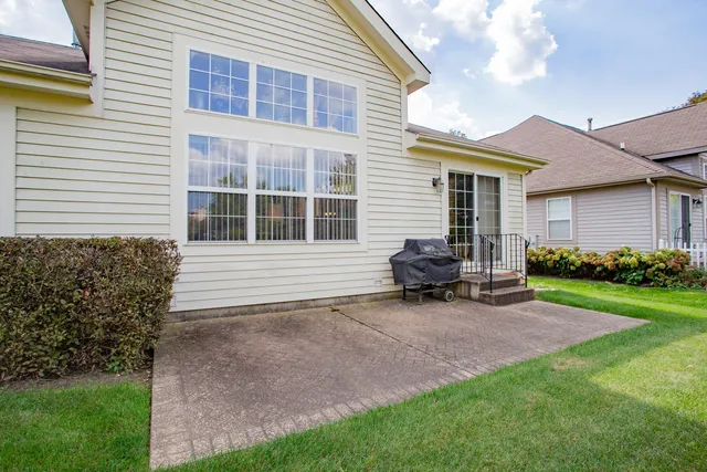 a backyard of a house with barbeque oven and outdoor seating