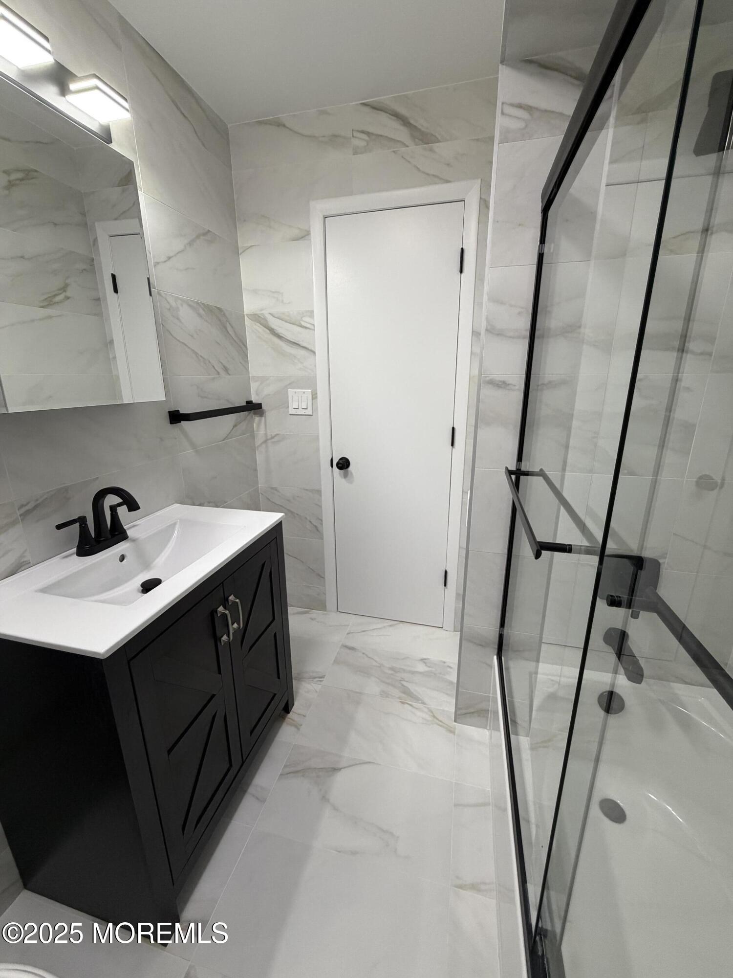 14 3rd Street Keyport, NJ 07735 - Photo 12 of 27 a bathroom with a sink a mirror and a shower