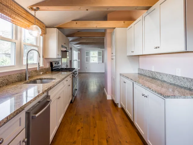 a large kitchen with granite countertop a sink and dishwasher stove a refrigerator with wooden cabinets