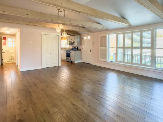 a view of empty room with wooden floor
