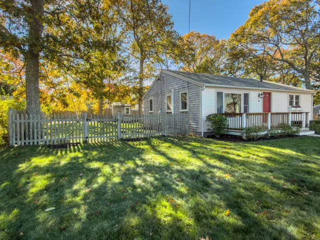 a view of a house with a backyard and a tree