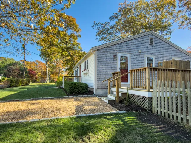 a view of a house next to a yard with big trees