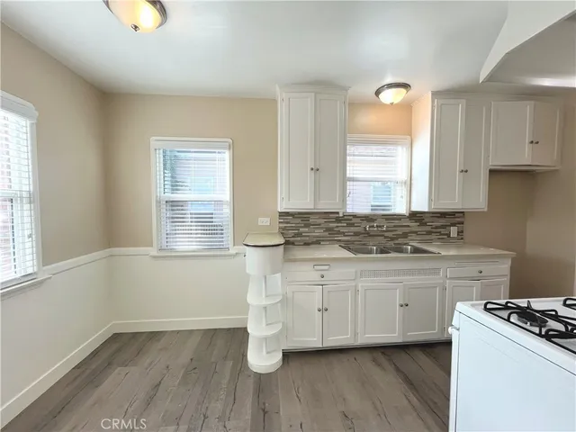 a kitchen with granite countertop a stove a sink and a window