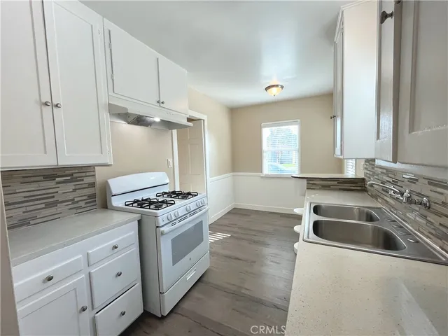 a kitchen with white cabinets and white appliances