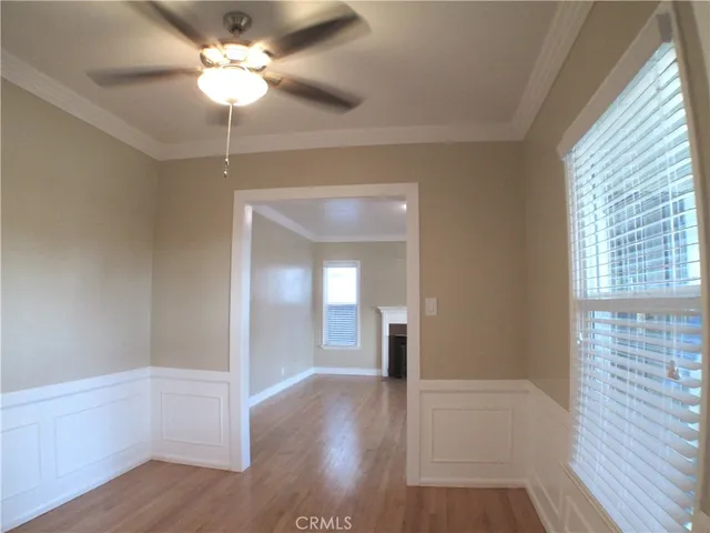 a view of a hallway with wooden floor and a chandelier