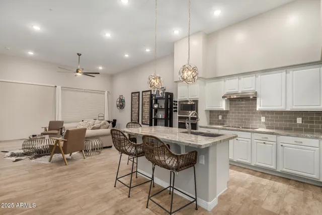 a kitchen with stainless steel appliances kitchen island granite countertop a sink and cabinets