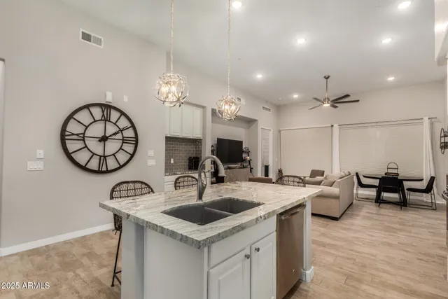 a kitchen with stainless steel appliances granite countertop a sink a stove and a wooden floors