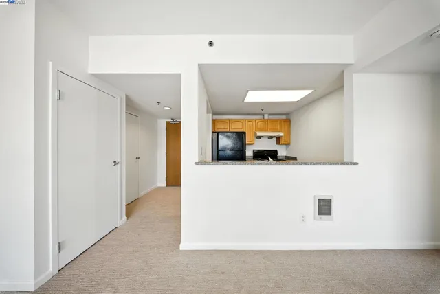 a living room with stainless steel appliances furniture a couch and a window