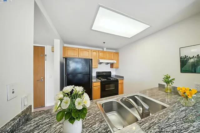 a kitchen with a refrigerator and a stove top oven