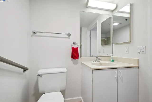 a bedroom with bed a flat tv screen and a potted plant