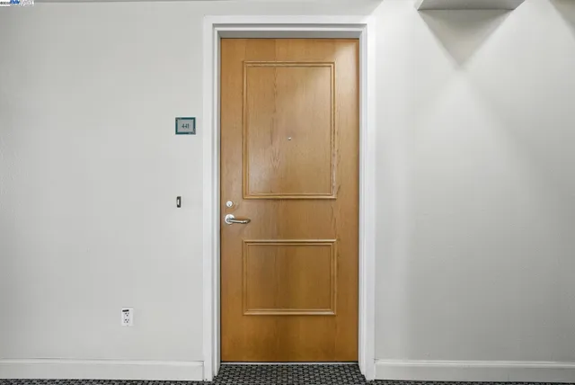 a view of a hallway with a livingroom and a bathroom with sink