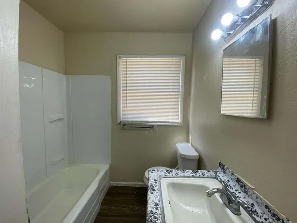 a bathroom with a sink a vanity and a bathtub