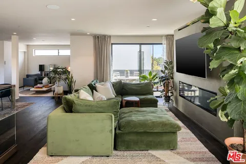 a living room with furniture a large window and a flat screen tv