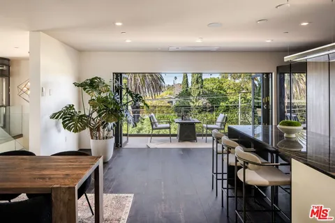 a living room with furniture a potted plant and open to kitchen