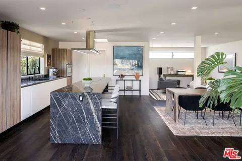 a living room with furniture a wooden floor and a chandelier
