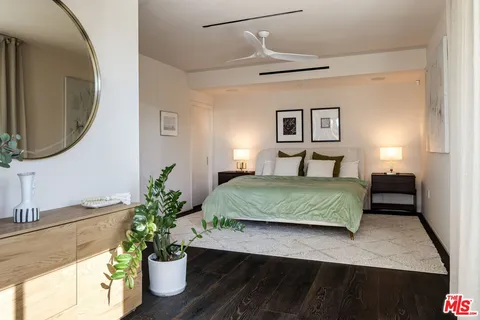 a bedroom with a large bed and a potted plant