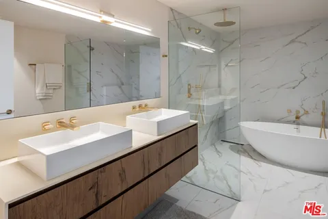 a bathroom with a double vanity sink mirror and bathtub