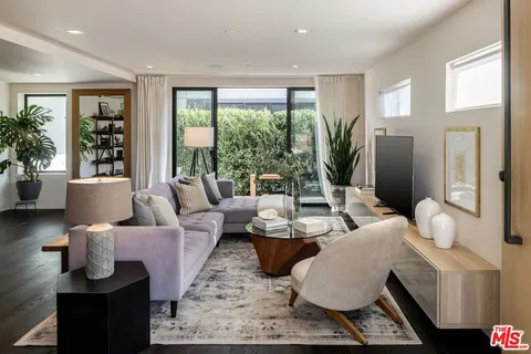 a living room with furniture and large windows