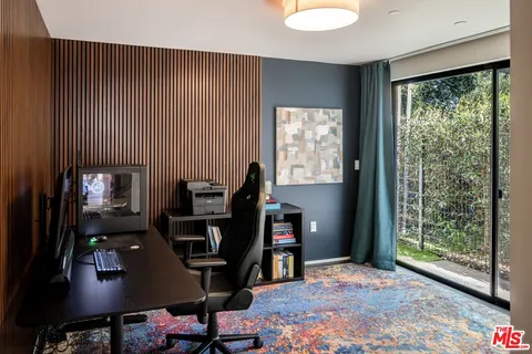 a view of a workspace with furniture and a window