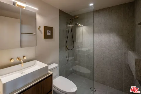 a bathroom with a granite countertop sink toilet and shower