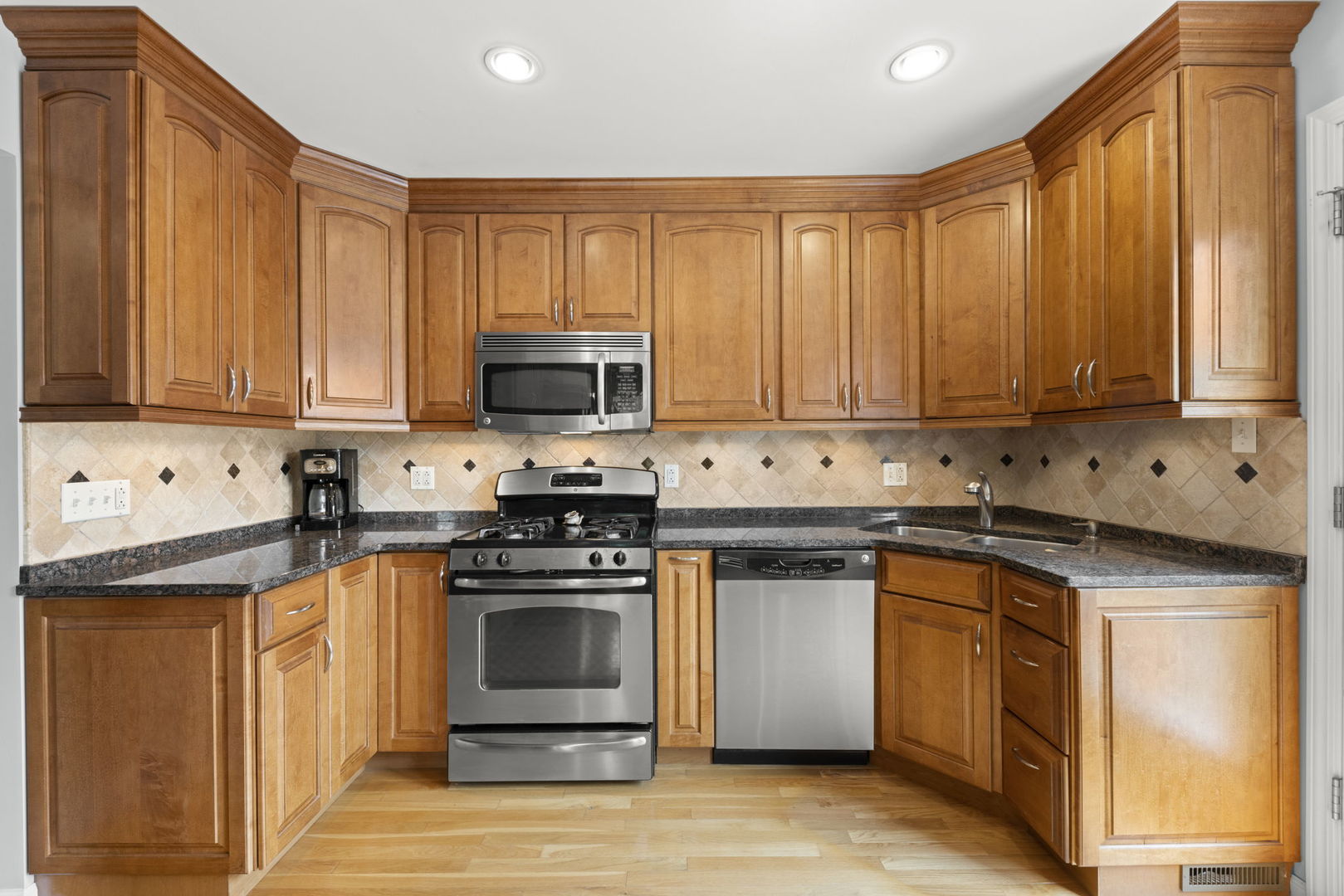 1635 South Prospect Street Wheaton, IL 60189 - Photo 13 of 53 a kitchen with stainless steel appliances granite countertop a stove a sink and a microwave