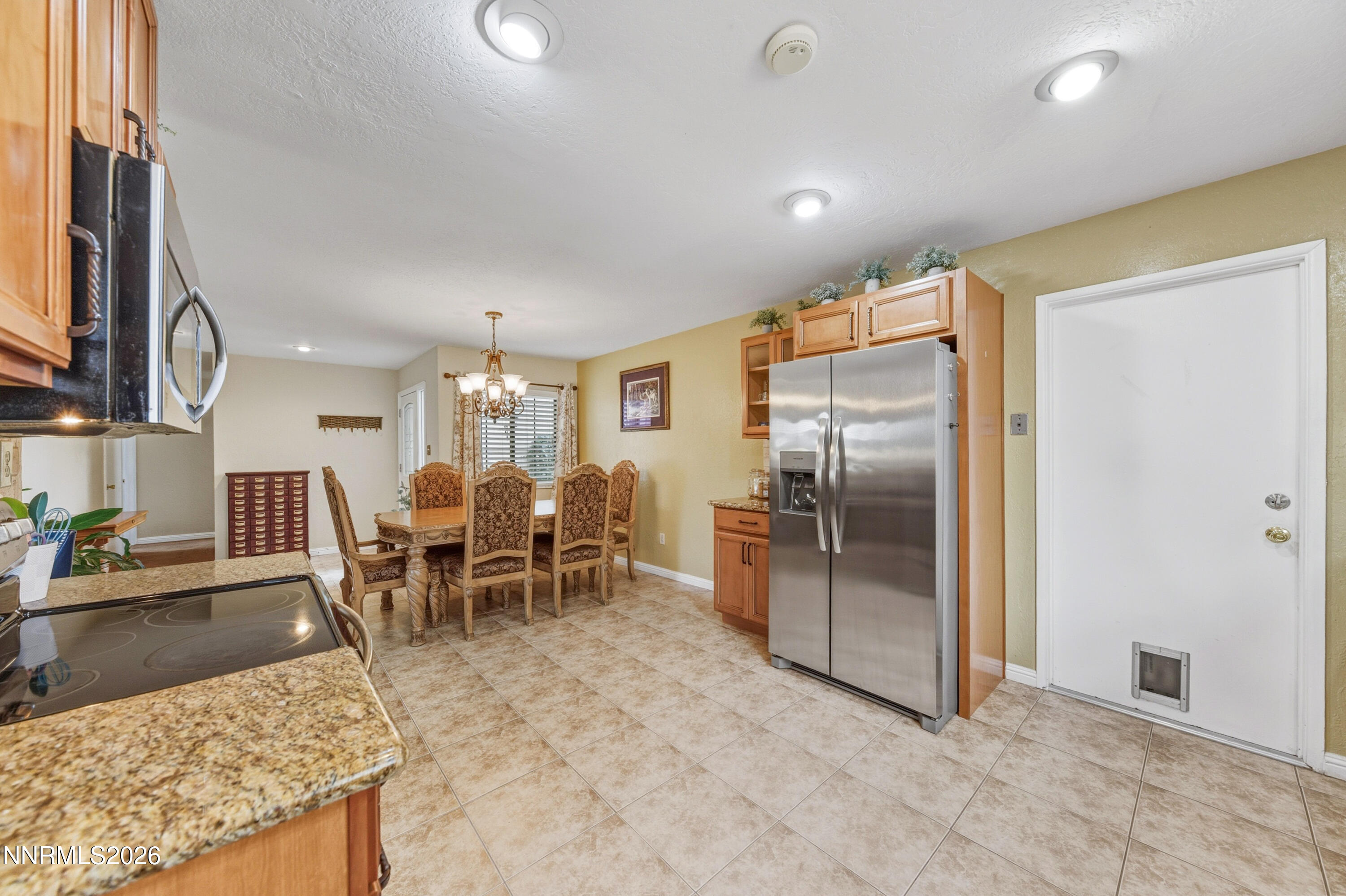 1540 O Farrell Street Reno, NV 89503 - Photo 13 of 41 a kitchen with stainless steel appliances kitchen island granite countertop dining table chair and a refrigerator