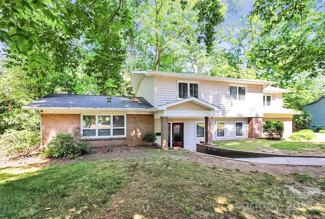 a front view of a house with a yard and trees