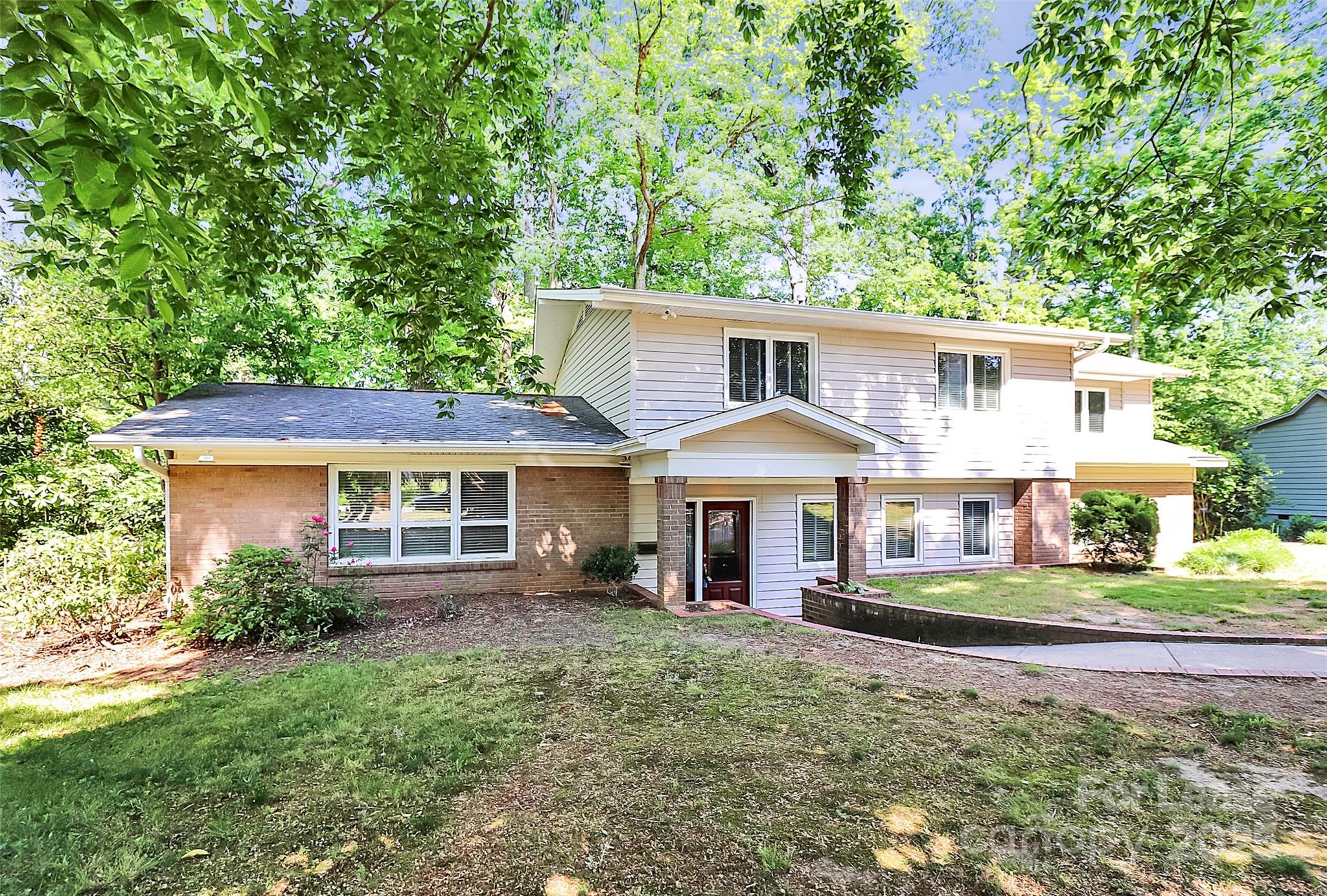 a front view of a house with a yard and trees
