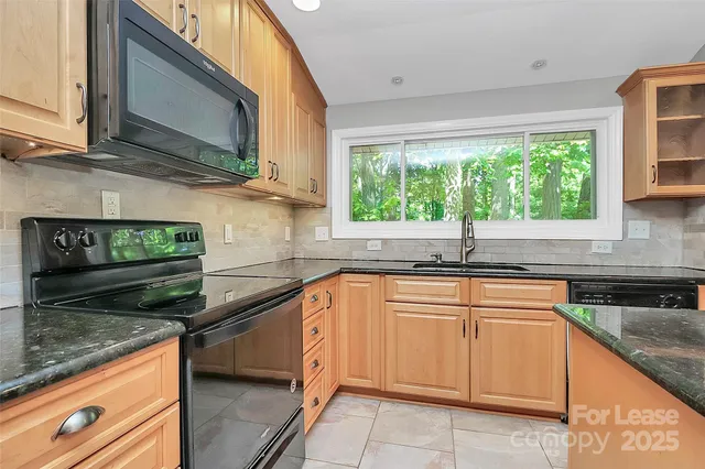 a kitchen with stainless steel appliances granite countertop a sink stove and cabinets